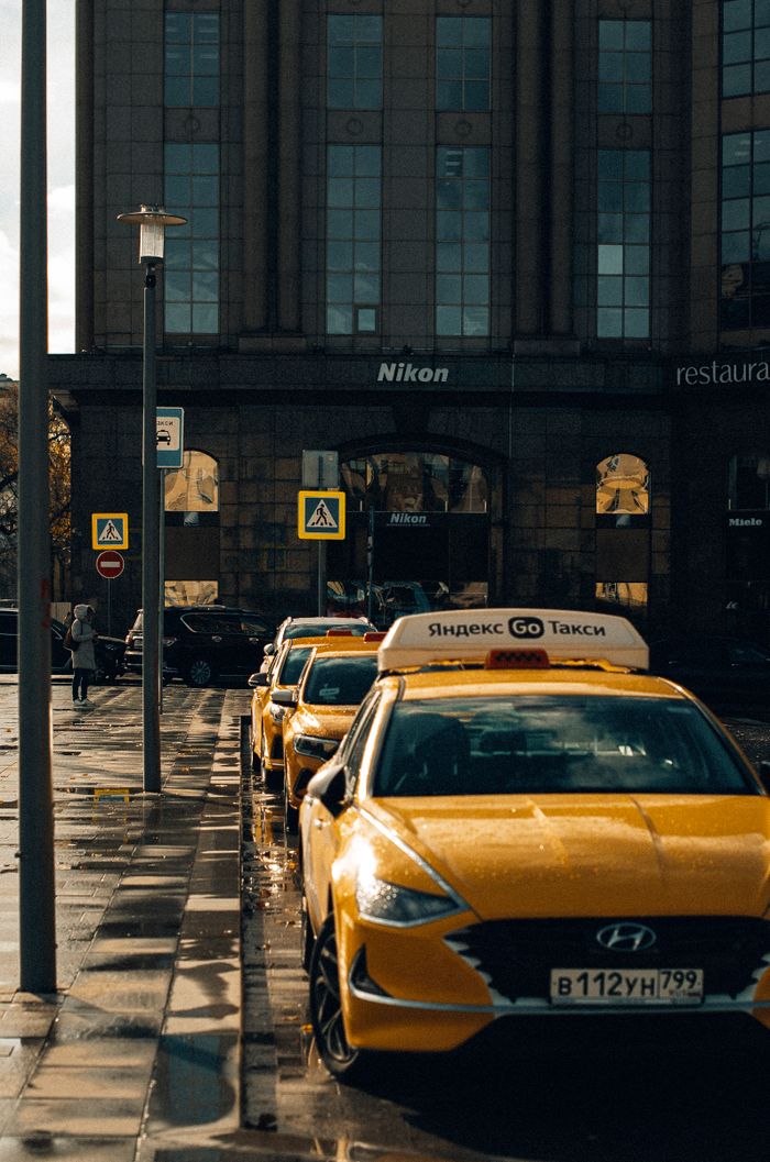 Mastering the First Impression: Your intriguing post title goes here Urban scene featuring parked yellow taxis on a city street in front of a building on a rainy day.