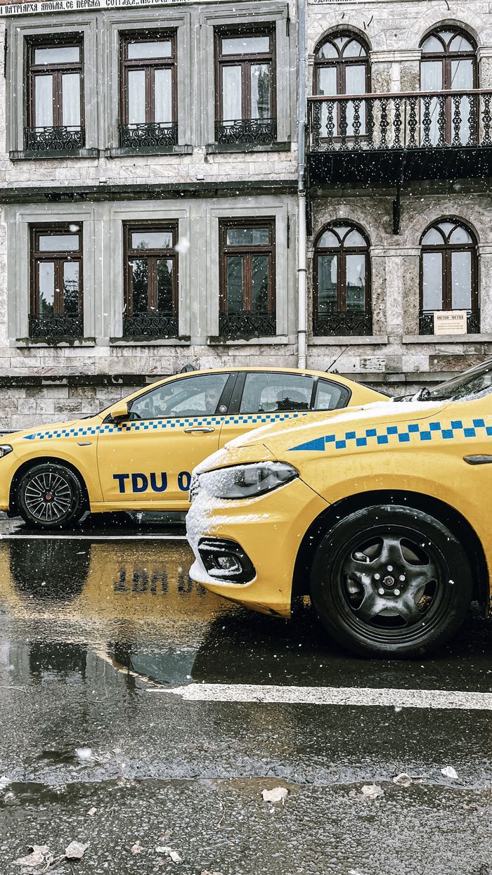 Crafting Captivating Headlines: Your awesome post title goes here Yellow taxis parked on a snowy street, vintage architecture backdrop.